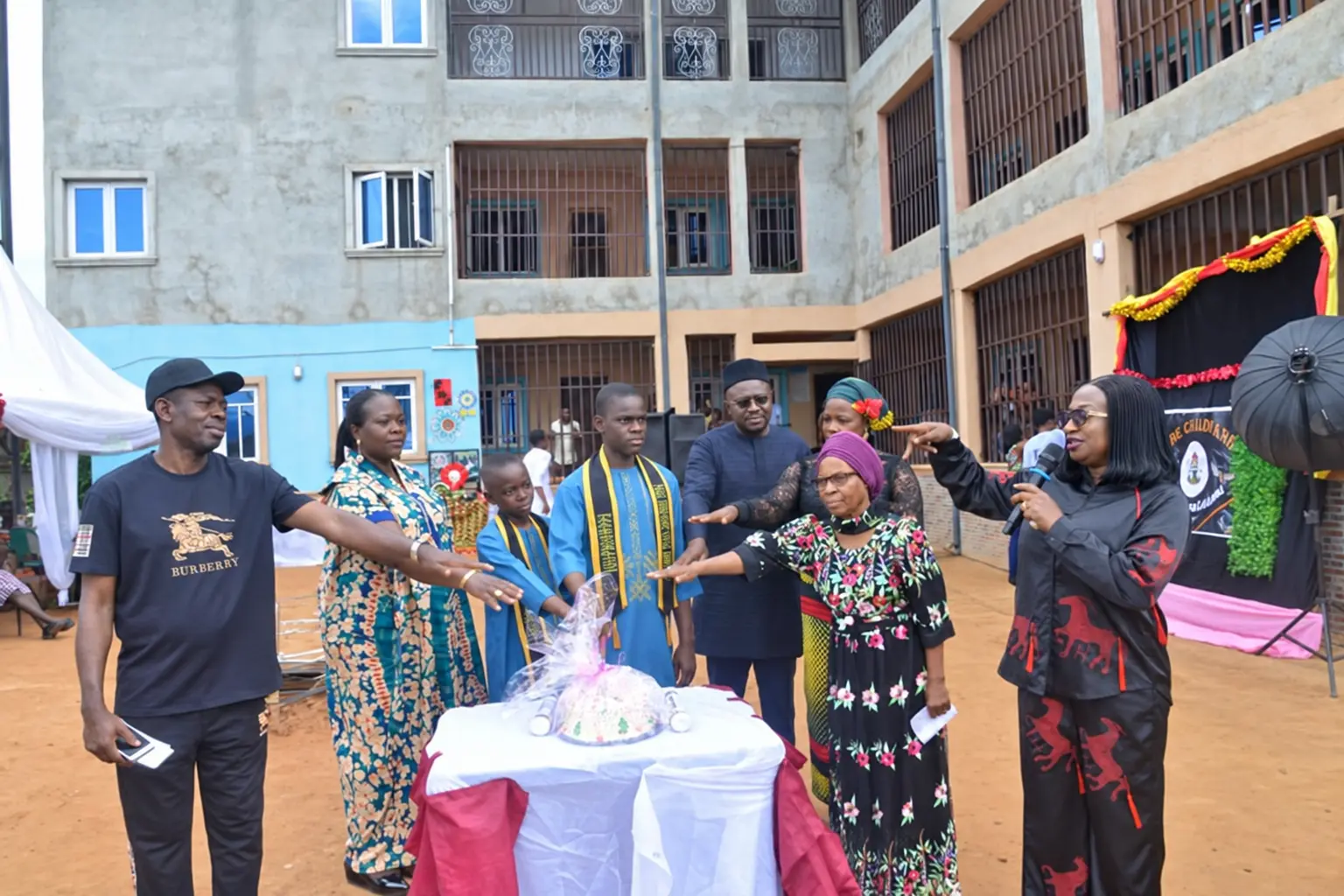 School community gathered around a table during an outdoor celebration